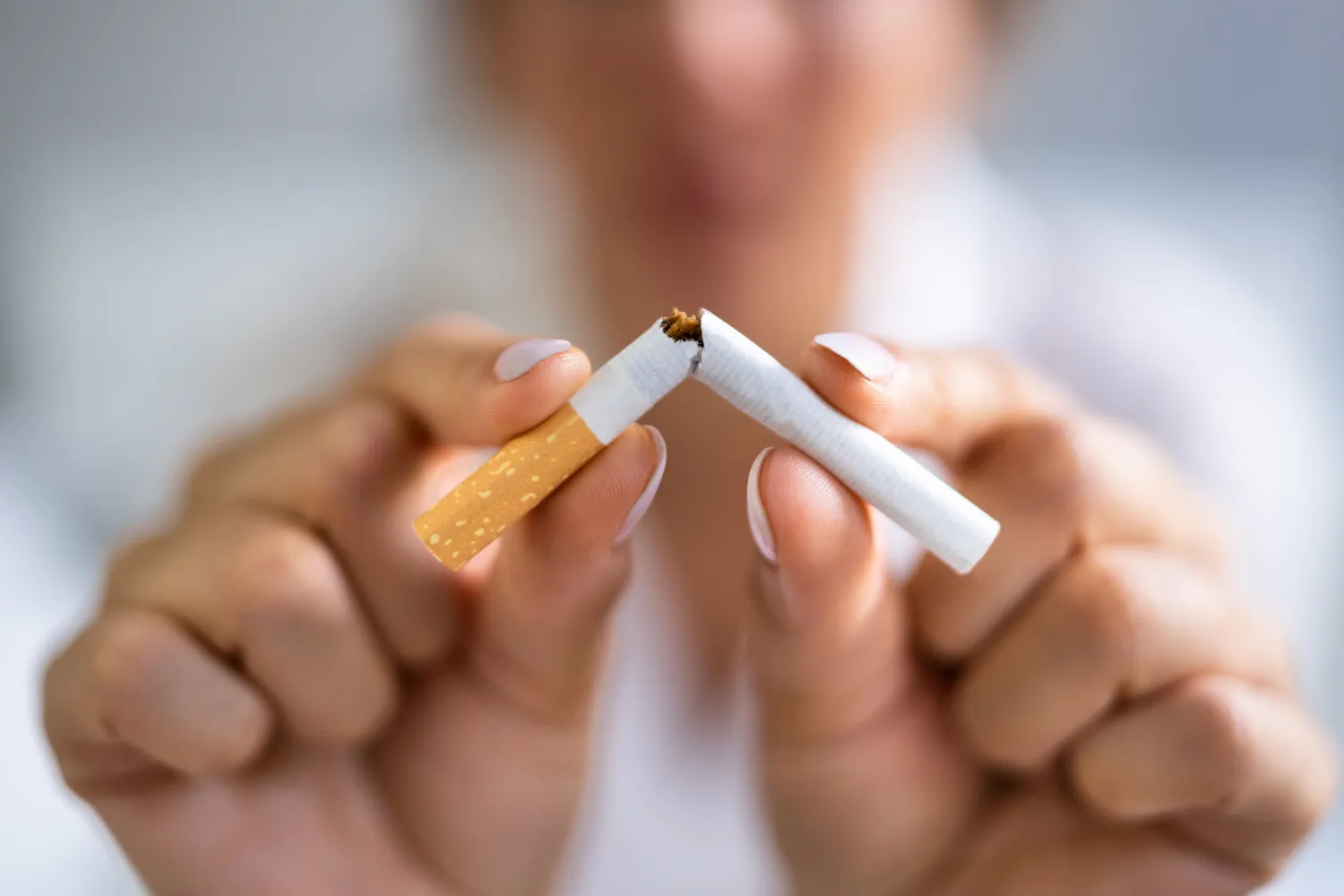 Mains qui cassent une cigarette en deux
